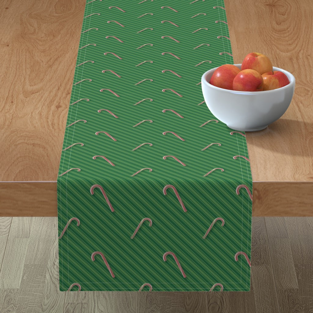 Bastones de caramelo en caminos de mesa con rayas verdes