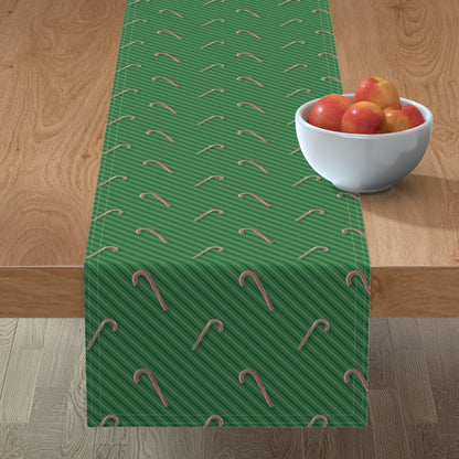 Bastones de caramelo en caminos de mesa con rayas verdes